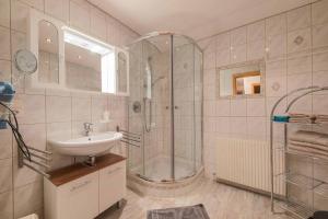 ein Bad mit einer Dusche und einem Waschbecken in der Unterkunft Haus Simone in Neustift im Stubaital