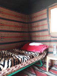 Al KhuraybahにあるFeynan wild campのストライプの壁の客室のベッド1台