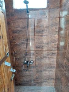 La salle de bains est pourvue d'une douche et d'un mur en bois. dans l'établissement Feynan wild camp, à Al Khuraybah