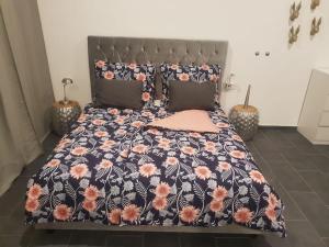 a bed with a black and pink floral comforter at Loft in Wien in Vienna