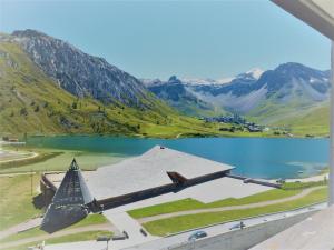 una vista di una chiesa con un lago e montagne di Studio cosy à Tignes, au pied des pistes et commerces - FR-1-411-481 a Tignes