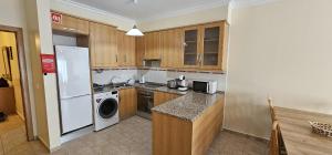 a kitchen with a white refrigerator and a dishwasher at Open Space - Albufeira in Albufeira