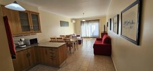 eine Küche und ein Wohnzimmer mit einem roten Sofa und einem Tisch in der Unterkunft Open Space - Albufeira in Albufeira