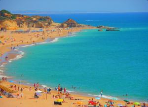 a group of people on a beach with the ocean at Open Space - Albufeira in Albufeira