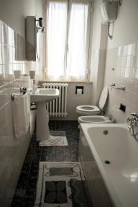 een badkamer met een wastafel, een toilet en een bad bij Il Glicine in Falerone
