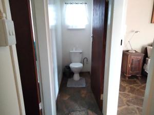 a small bathroom with a toilet and a window at Doornspruit Farm in Magaliesburg