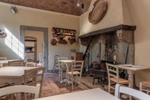 un restaurant avec des tables, des chaises et une cheminée dans l'établissement Convento San Bartolomeo, à Abbadia San Salvatore