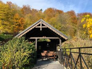 - un pavillon en bois avec une table et des chaises dans l'établissement Willa Pod Bocianem, à Ojców