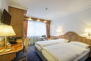 Postel nebo postele na pokoji v ubytování Hotel Alpenroyal