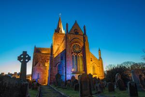 an old church with a cross in front of it at Stay Kirkwall Apartments - Ayre Road in Kirkwall +1 photo