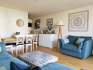 ein Wohnzimmer mit einem blauen Sofa und einem Tisch in der Unterkunft Wild Sands Next to Beach ✩ Cinema ✩ Living Roof ✩ Games Room in Camber