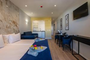 a hotel room with two beds and a living room at Emeralds Albufeira in Albufeira
