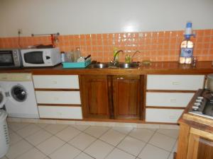 eine Küche mit einer Spüle und einer Mikrowelle in der Unterkunft Villa au Tamtam in Gandigal