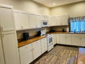 WabashにあるModern Farmhouse 3 Bed, 2 Bath Apartment, Sleeps 7, Lots of Space, Steps to Downtown, Honeywell & Eagles Theaterのキッチン(白いキャビネット、白い電化製品付)