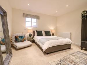 a bedroom with a bed and a chair in it at Walnut View in Rugeley