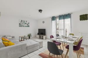 a living room with a white couch and a table at Budget spacious apart with terrace in Mantes-la-Jolie