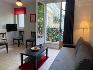 un soggiorno con divano, tavolo e finestra di Appartement Coeur de Ville a Chinon