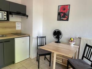 una piccola cucina con tavolo e sedie in legno di Appartement Coeur de Ville a Chinon