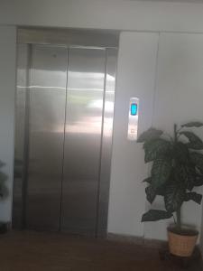 an elevator in a building with a plant next to it at Apartamento Melgar - Altagracia in Melgar