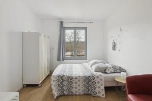 a white bedroom with a bed and a window at Budget spacious apart with terrace in Mantes-la-Jolie
