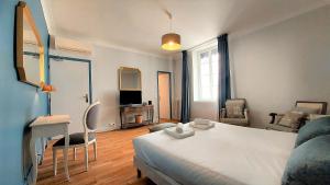 1 dormitorio con 1 cama blanca grande y escritorio en Hôtel De L'Amphithéâtre, en Nimes
