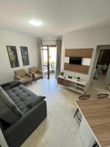 sala de estar con sofá y TV en Apartamento beira mar em Ponta das Canas en Florianópolis