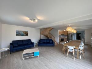 a living room with a blue couch and a table at Naturotel in Fort-Mahon-Plage