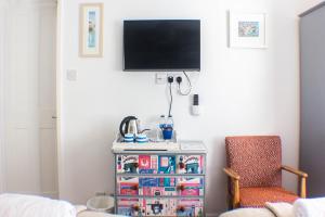 a living room with a tv and a chair at No4 St Ives in St Ives