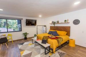 a bedroom with a yellow bed and a table at Incredible Apartment Avándaro in Valle de Bravo