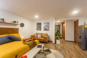 a bedroom with a yellow bed and a couch at Incredible Apartment Avándaro in Valle de Bravo