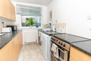 a kitchen with a stove and a dishwasher at 'Sunset View' Eclectic & Stylish One Bed Apartment (3 guests) in Fife