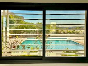 迦瑪特的住宿－Gammarth Touristique piscine commune bord de mer，享有游泳池景致的窗户