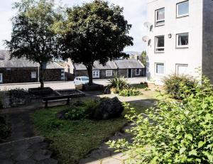 a park with a bench in front of a building at 'Sunset View' Eclectic & Stylish One Bed Apartment (3 guests) in Fife