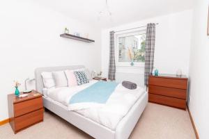 a bedroom with a white bed and a window at 'Sunset View' Eclectic & Stylish One Bed Apartment (3 guests) in Fife