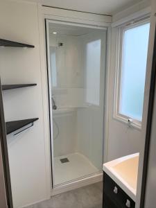 维亚斯Mobilhome Vias plage dans Camping的带淋浴和玻璃门的浴室