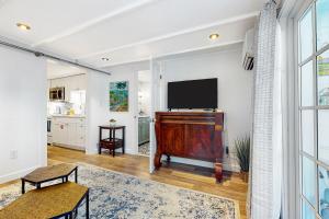 een woonkamer met een flatscreen-tv aan de muur bij The Coral Cove in Key West