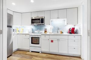 een witte keuken met witte kasten en een magnetron bij The Coral Cove in Key West +3 foto's