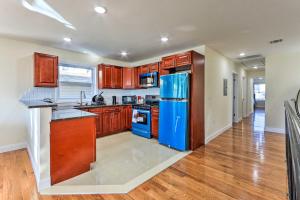 eine Küche mit Holzschränken und einem blauen Kühlschrank in der Unterkunft Bright Irvington Home about 2 Mi to Prudential Center! in Irvington