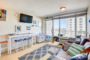 a living room with a couch and a table at Daytona Beach Studio with Balcony and Ocean View in Daytona Beach