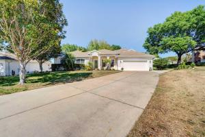 a white house with a tree and a driveway at Stunning Minneola Home with Private Pool and Yard! in Minneola