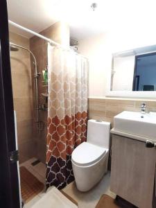 ein Bad mit einem WC, einem Waschbecken und einer Dusche in der Unterkunft RW 5F 5 Cozy 2BR Goshen Land Towers, in Baguio City
