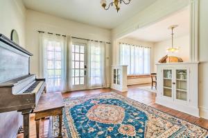 a living room with a piano and a rug at Historic Home Near Downtown Little Rock! in Little Rock