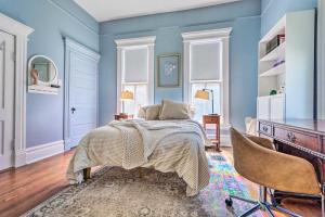 um quarto com paredes azuis e uma cama e uma cadeira em Historic Home Near Downtown Little Rock! em Little Rock