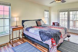 Schlafzimmer mit einem Bett, einem Tisch und Fenstern in der Unterkunft Remote Tennessee Home with Deck, Fireplace, and Creek! in Lyles