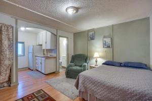 a bedroom with a bed and a chair and a kitchen at Pet-Friendly Loveland Studio Near Boyd Lake! in Loveland