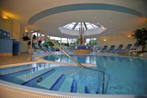 a swimming pool in a hotel with a slide in it at Parkhotel Flora am Schluchsee in Schluchsee