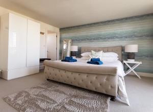 1 dormitorio con 1 cama grande y una pintura en la pared en Wild Sands Next to Beach ✩ Cinema ✩ Living Roof ✩ Games Room en Camber