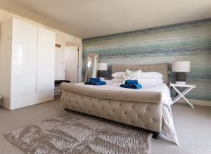 a bedroom with a large bed with a painting on the wall at Wild Sands Next to Beach ✩ Cinema ✩ Living Roof ✩ Games Room in Camber