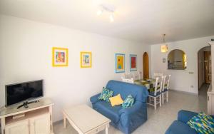 a living room with a blue couch and a table at Las Terrazas - Apartamento en segunda línea Playa Cargador ALBERT VILLAS in Alcossebre