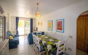 a dining room with a table and chairs and a couch at Las Terrazas - Apartamento en segunda línea Playa Cargador ALBERT VILLAS in Alcossebre